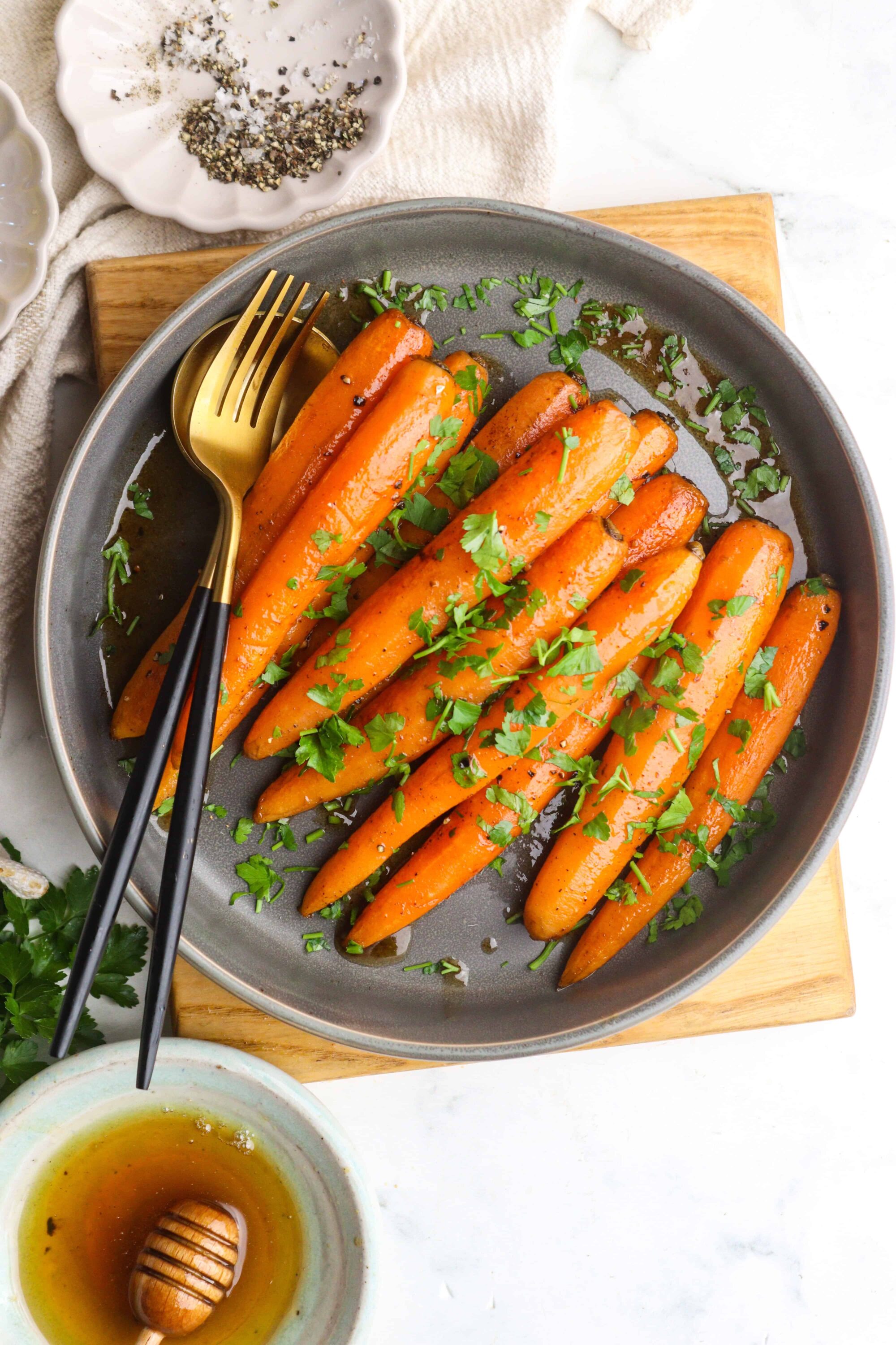 Roasted carrots with herbs on a gray plate at baked bree.