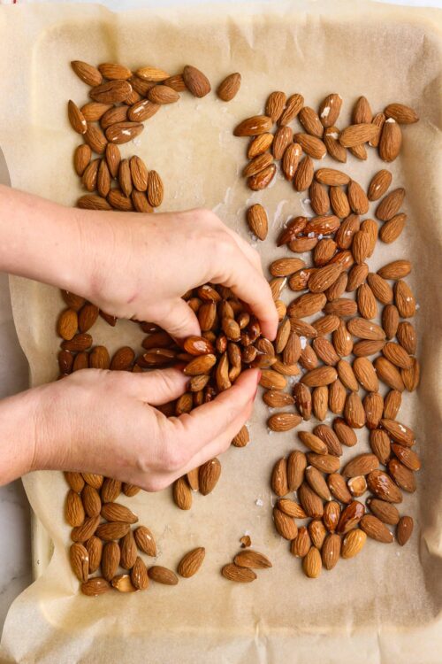 Toasting almonds on baking sheet for crispy nut snack or baking recipes.