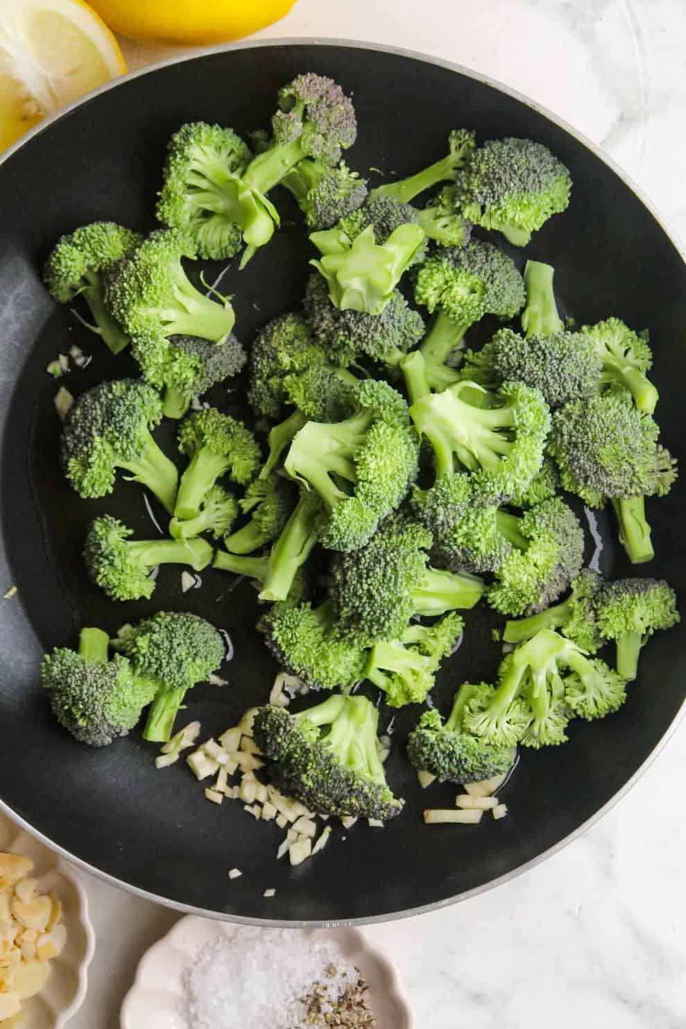 Steamed broccoli florets in a black skillet for healthy cooking.