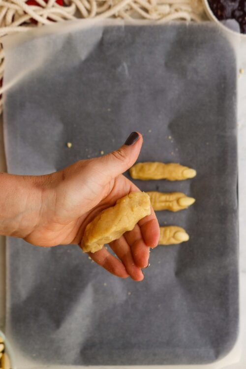 Buttery cookie dough being shaped by hand for baking cookies.
