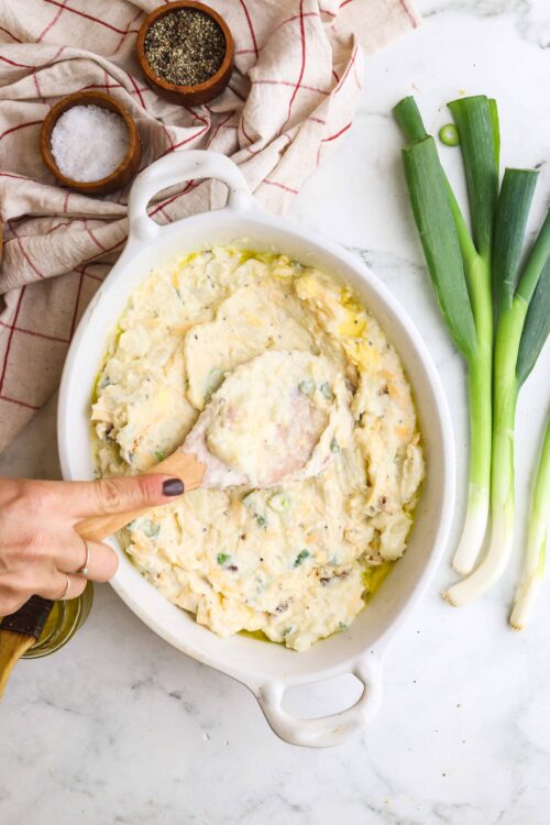 Creamy mashed potatoes with green onions in a baking dish, ready to serve.