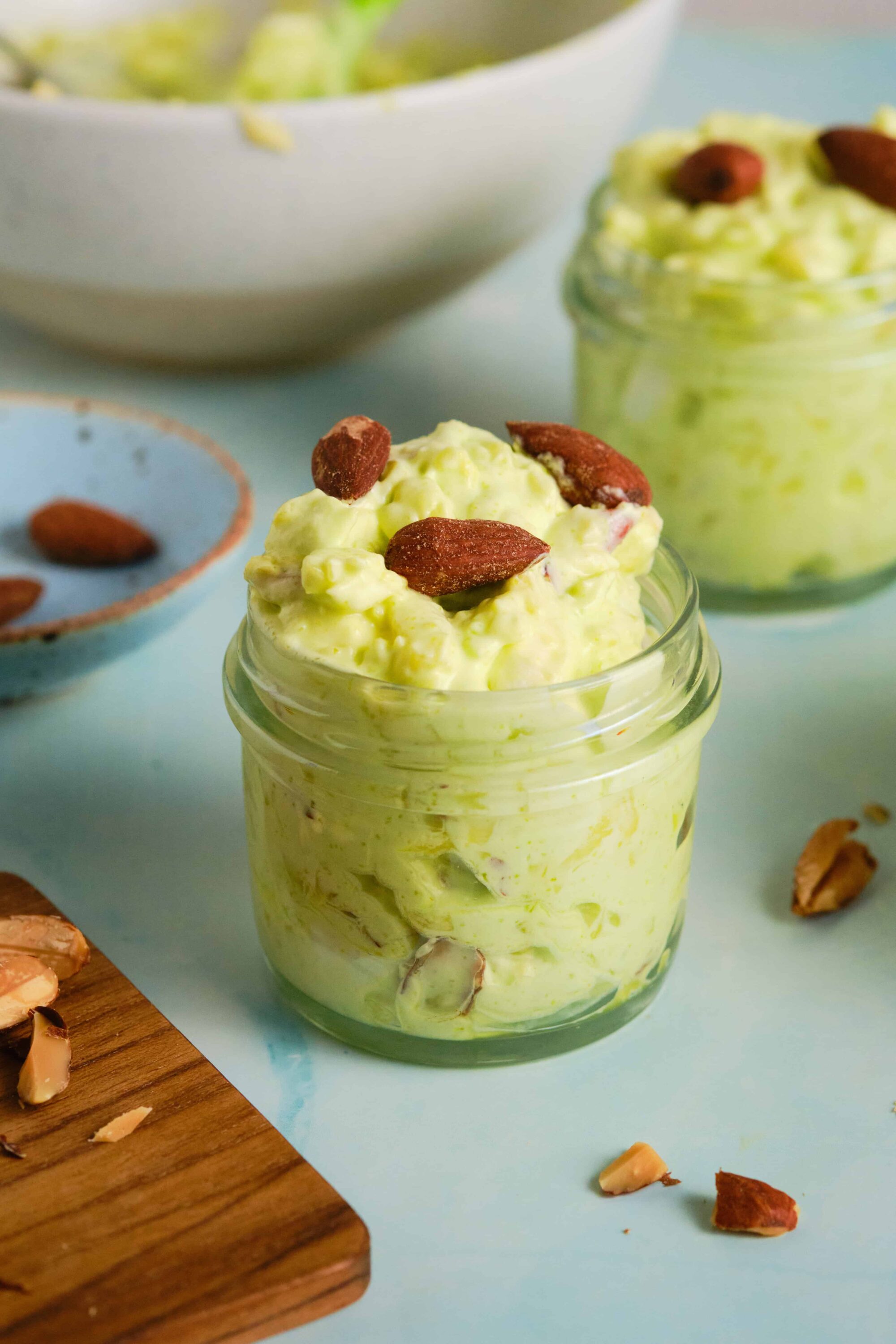 Creamy avocado turkey salad in small glass jar with almonds on top, fresh ingredients, healthy lunch idea.