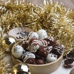 Decadent chocolate truffles with holiday sprinkles in a rustic bowl, perfect for Christmas desserts and festive treats.