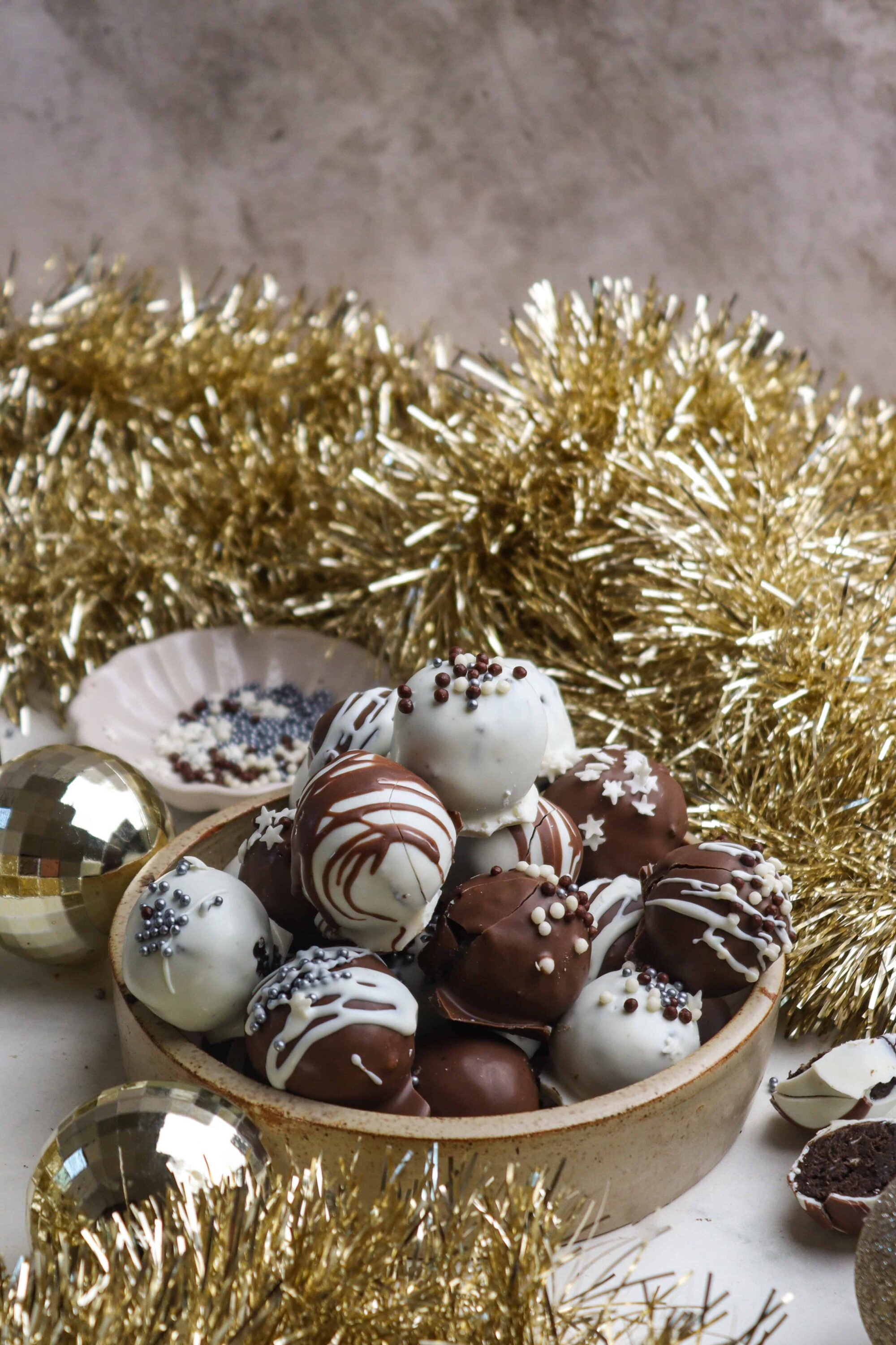 Delicious assorted chocolate truffles with holiday sprinkles in a cozy bowl.