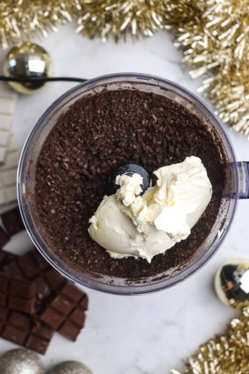 Rich chocolate Oreo crust with cream cheese mixture for a no-bake cheesecake. Perfect holiday dessert with festive decor.