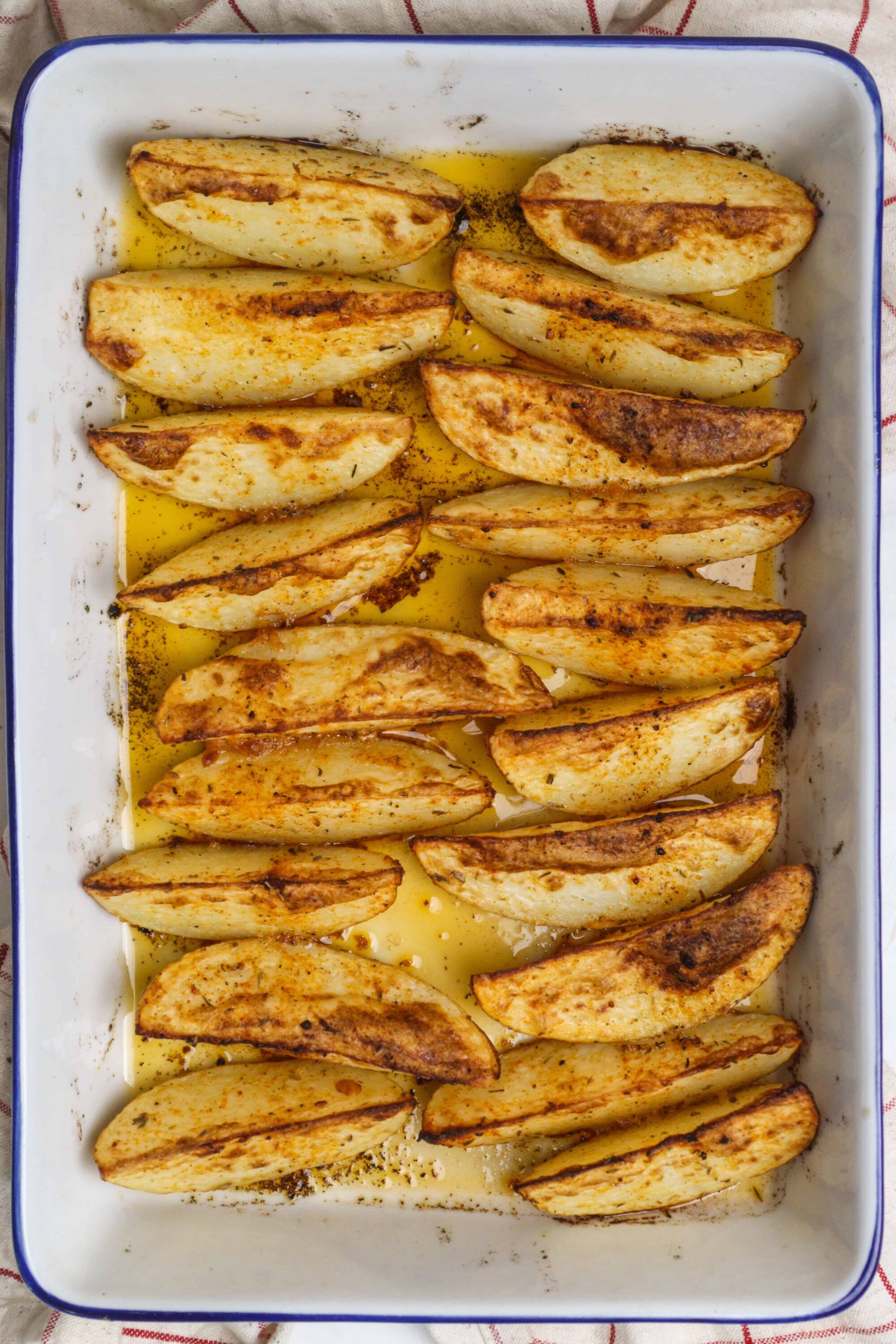 Roasted cinnamon-spiced apple wedges in a baking dish.