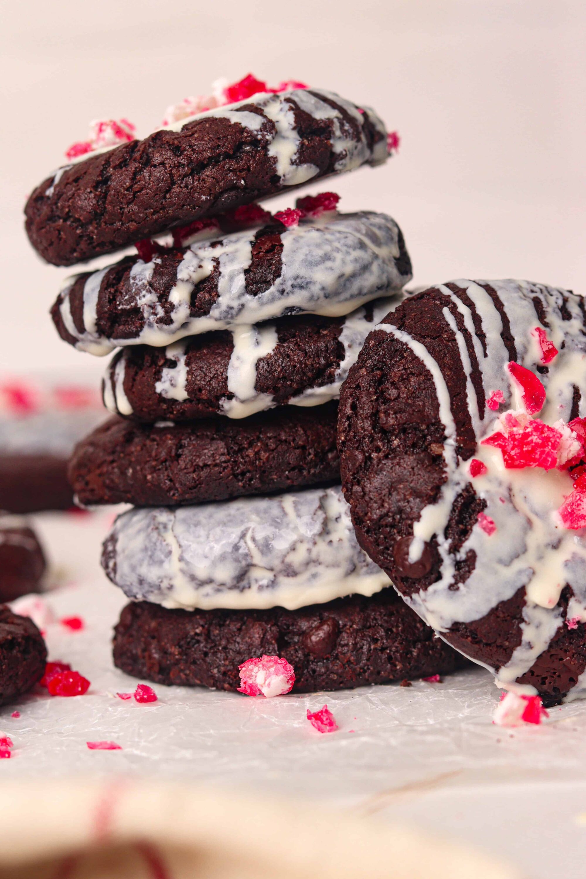 Fudgy chocolate cookies drizzled with white chocolate and topped with red sprinkles, perfect for dessert lovers.