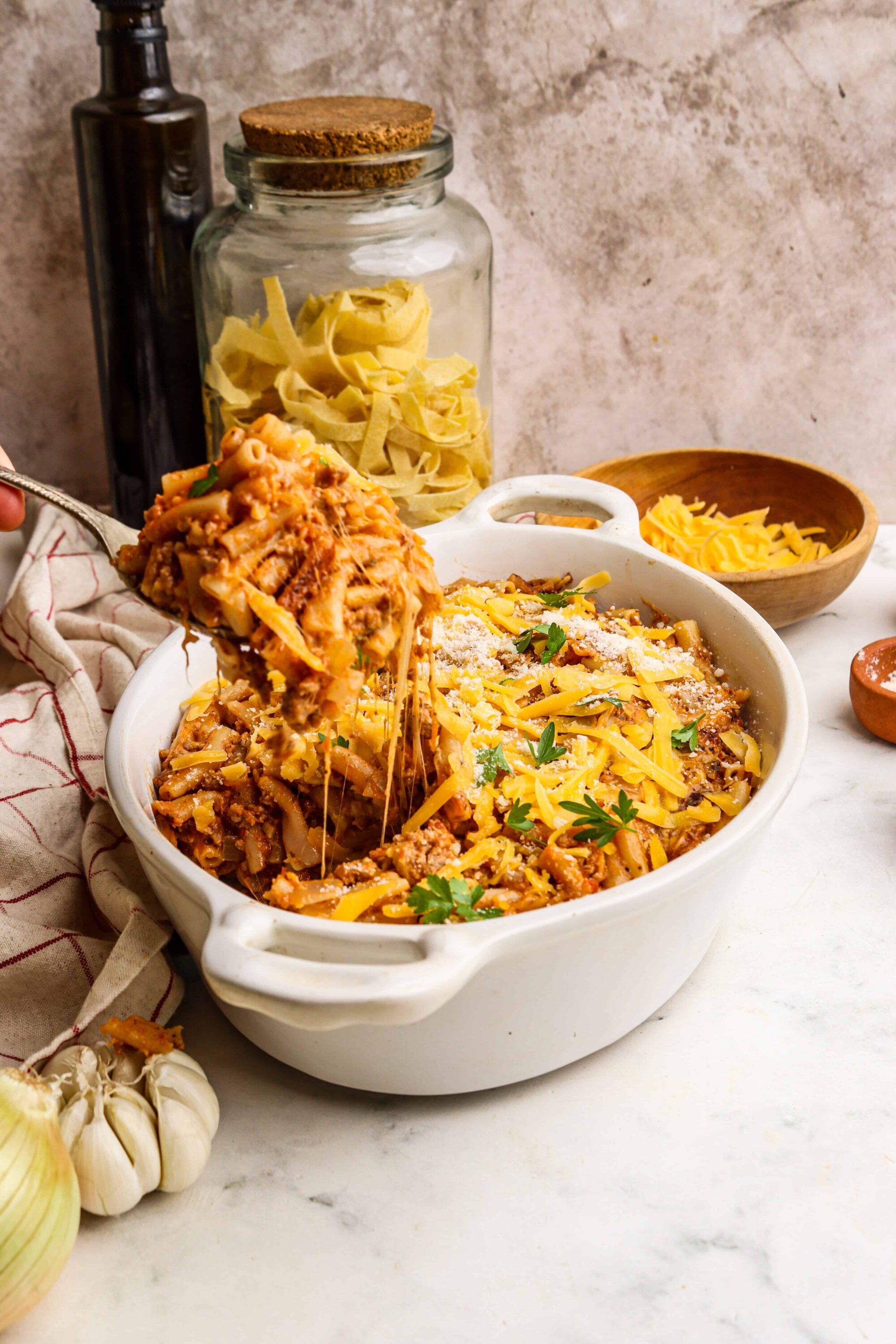 Creamy baked lasagna with melted cheese and savory meat sauce, served in a white ceramic dish.