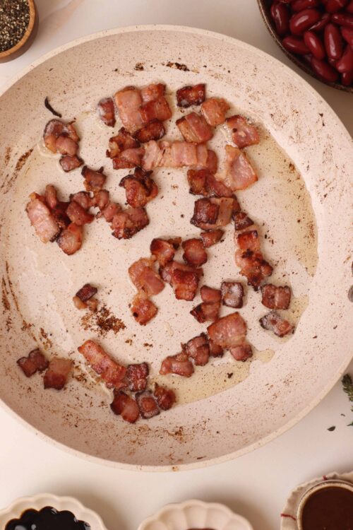 Crispy cooked bacon bits in a skillet; perfect for breakfast or recipes.