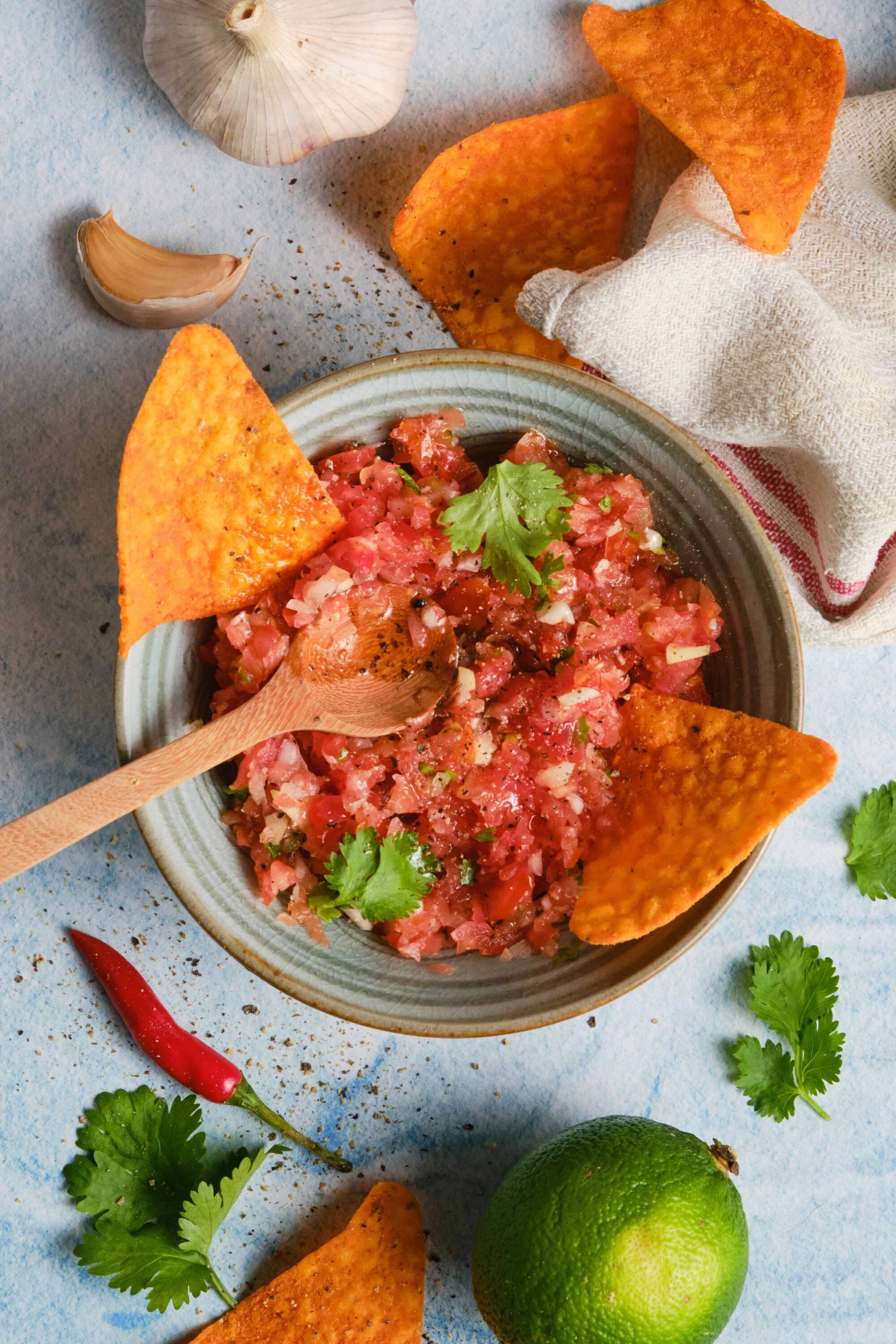 Fresh homemade pico de gallo with tortilla chips on a rustic table.