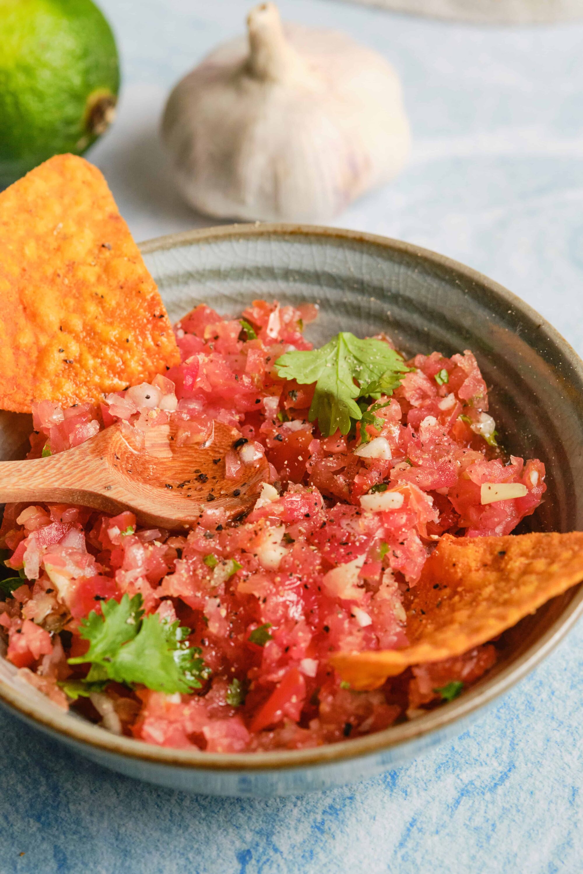 Fresh salsa made with diced tomatoes, onions, garlic, cilantro, and lime in a rustic bowl.
