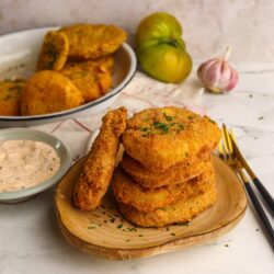 Golden crispy fried chicken tenders with parsley, served on a wooden plate. Perfect comfort food with creamy dipping sauce.
