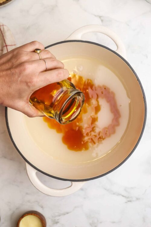 Sweetener being added to a cooking pot with caramel sauce.