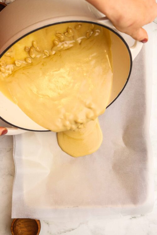 Butter and pine nut filling being poured onto parchment paper for baking.