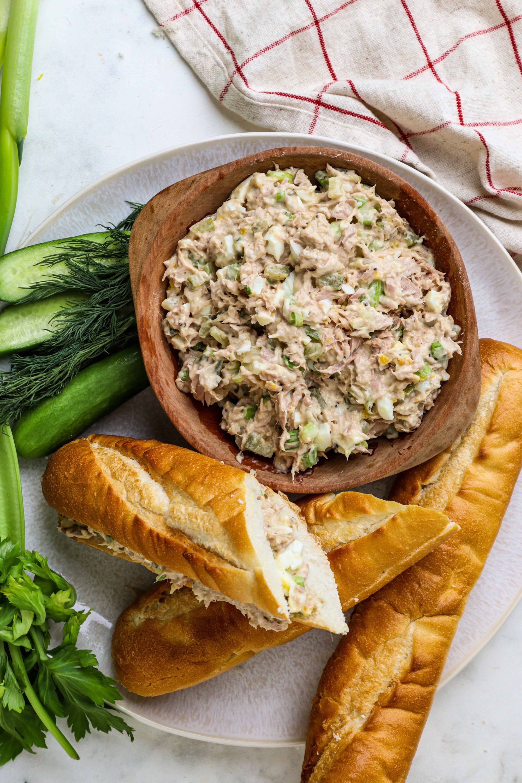 Creamy tuna salad with fresh vegetables served with baguette sandwiches and seasonal greens.