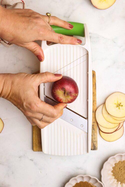 Slicing-apple-on-slicer-for-baked-goods, 150 characters.