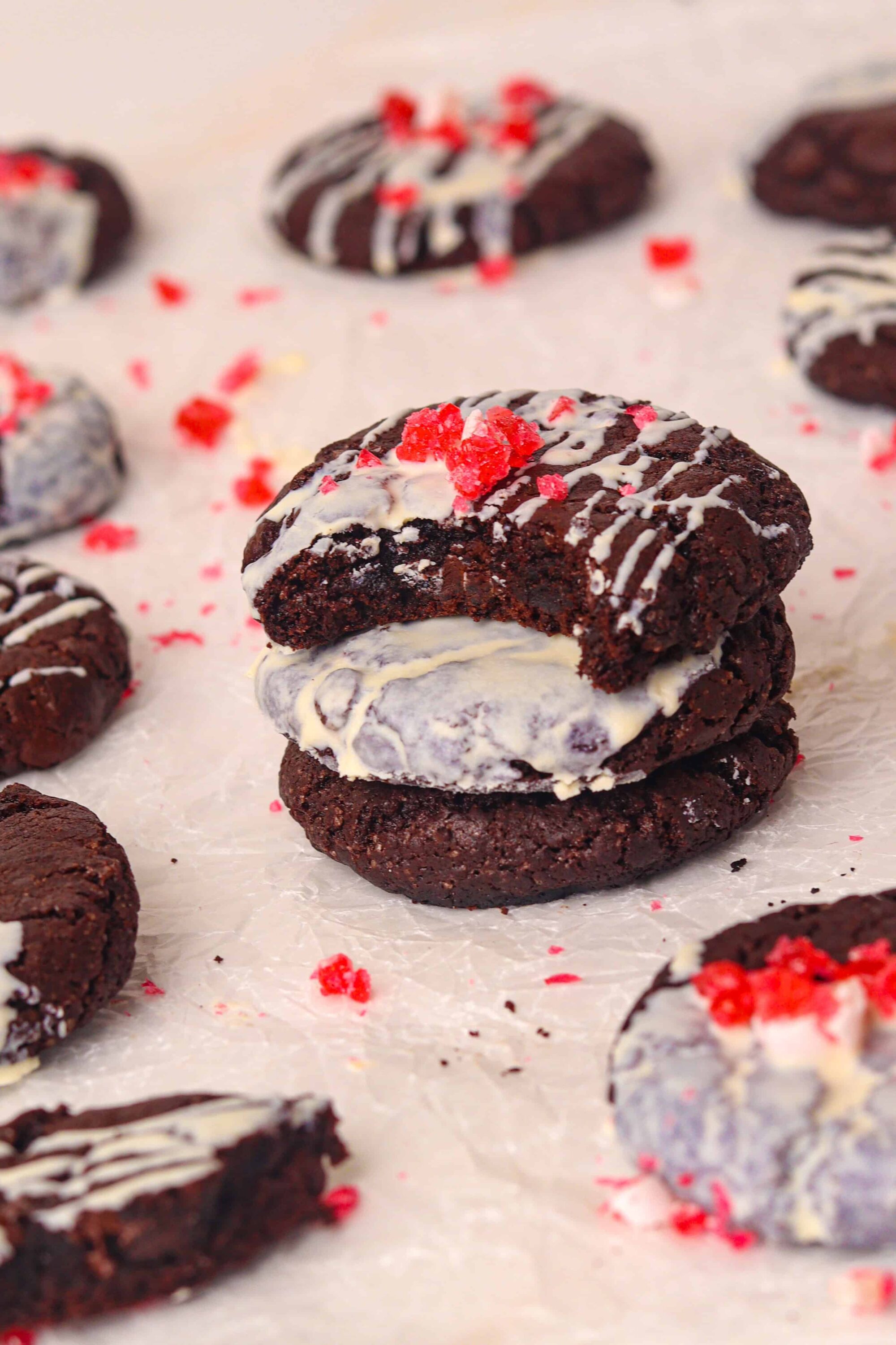 Rich chocolate cookies with vanilla ice cream and red sprinkles on parchment paper.