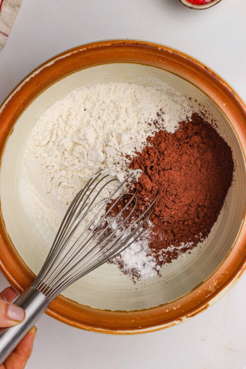Flour and cocoa powder in a mixing bowl for baking recipes.