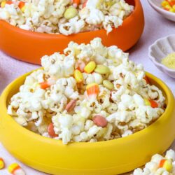 Butter popcorn with candy corn and honey nut Cheerios in colorful bowls, perfect for Halloween treats, snack ideas, fall party food, and movie nights.