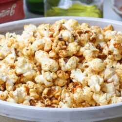 Buttered popcorn with seasoning in a white bowl.