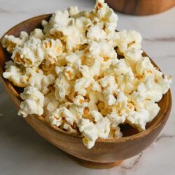 Buttered popcorn in a wooden bowl, snack, movie night, crunchy popcorn, fresh popcorn, baked Bree, flavorful snack, homemade popcorn, popcorn kernel.