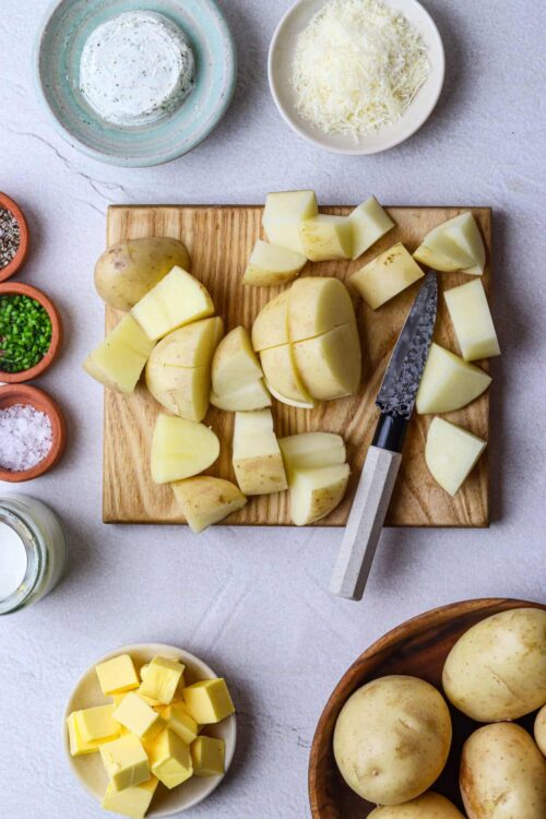 Fresh chopped potatoes on a wooden cutting board for homemade potato dishes.