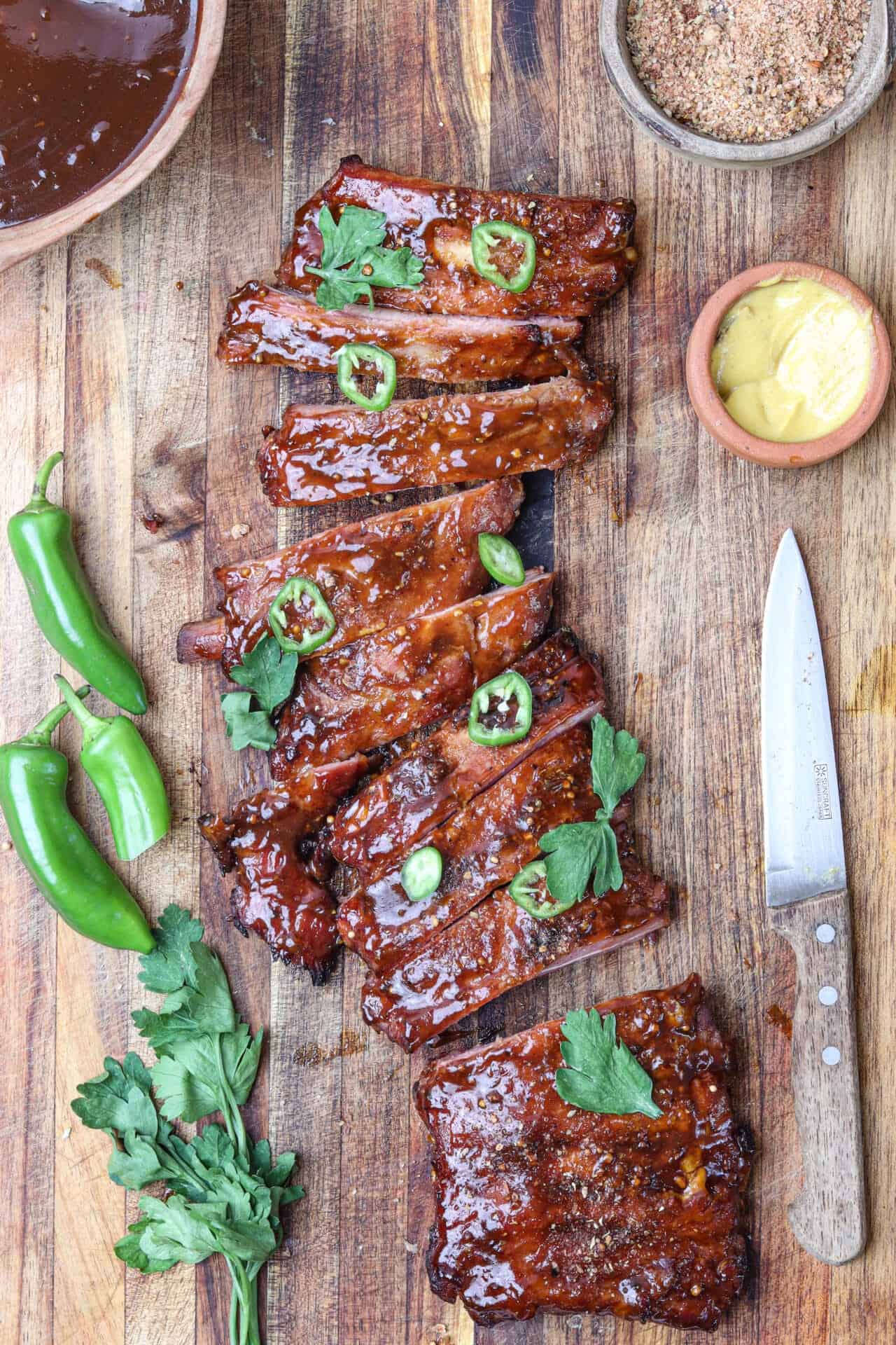 Succulent glazed pork ribs garnished with fresh herbs and sliced jalapeños.