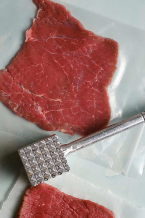 Fresh raw steak cut into pieces on a kitchen scale.