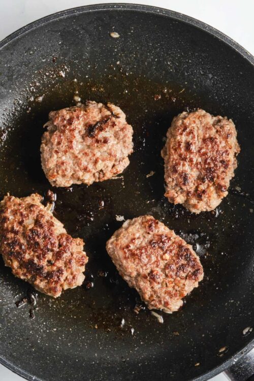 Juicy homemade beef meatballs cooking in a non-stick skillet for delicious recipes.