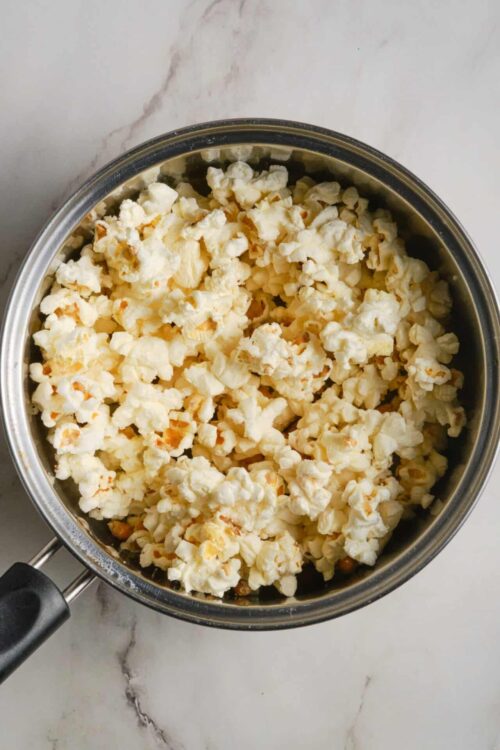 Fluffy popcorn in a stainless steel pot ready for seasoning or eating.