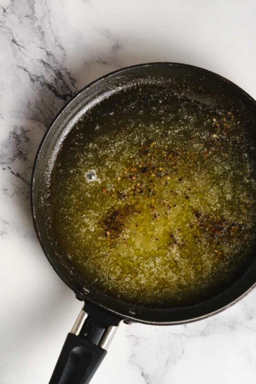 Buttered pan with seasoning and oil residue for baking or cooking.