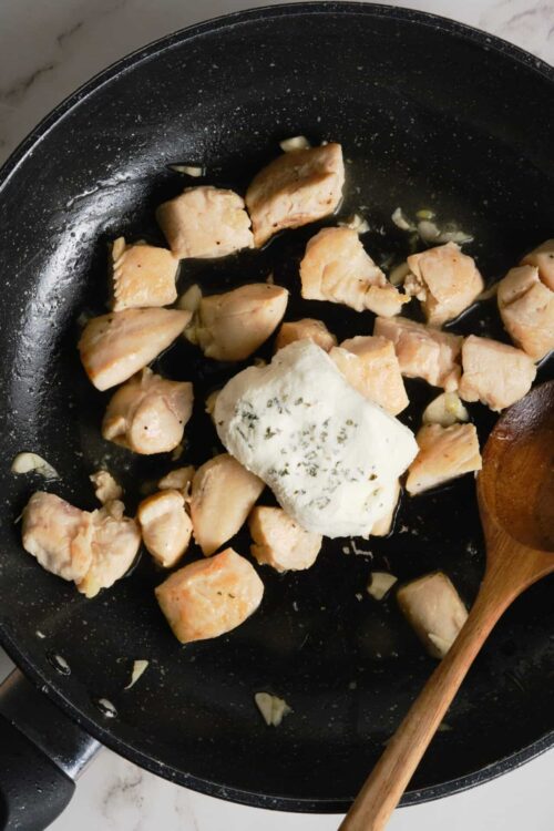Sautéed chicken breasts with garlic in a non-stick skillet.