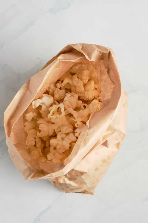 Crispy popcorn in brown paper bag, snack, movie night, homemade popcorn, crispy snack.