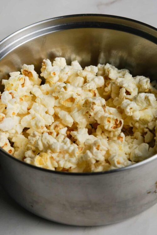 Buttered popcorn in a metal bowl.