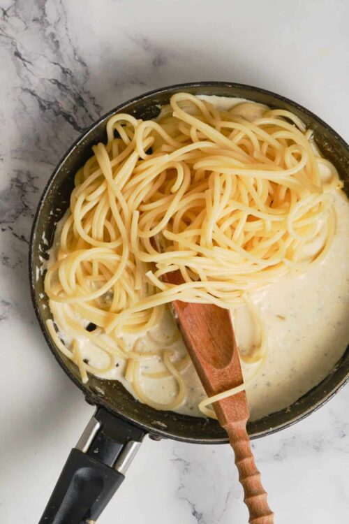 Creamy garlic Parmesan spaghetti cooking in a skillet with pasta and sauce, easy pasta recipe.