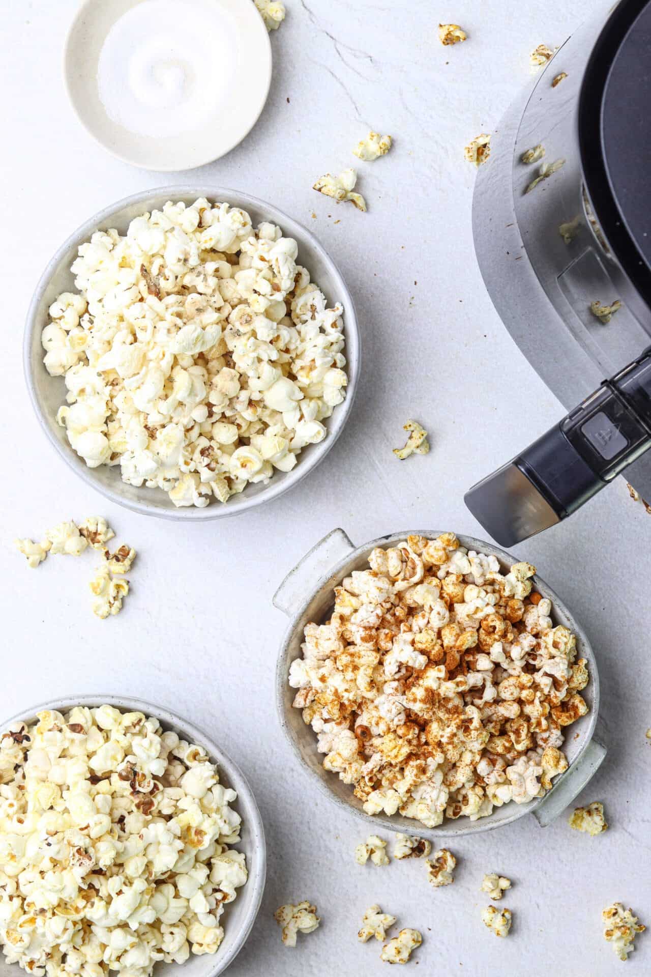 Buttery popcorn in bowls, freshly popped with different flavors, ready for snacking, homemade popcorn recipes.