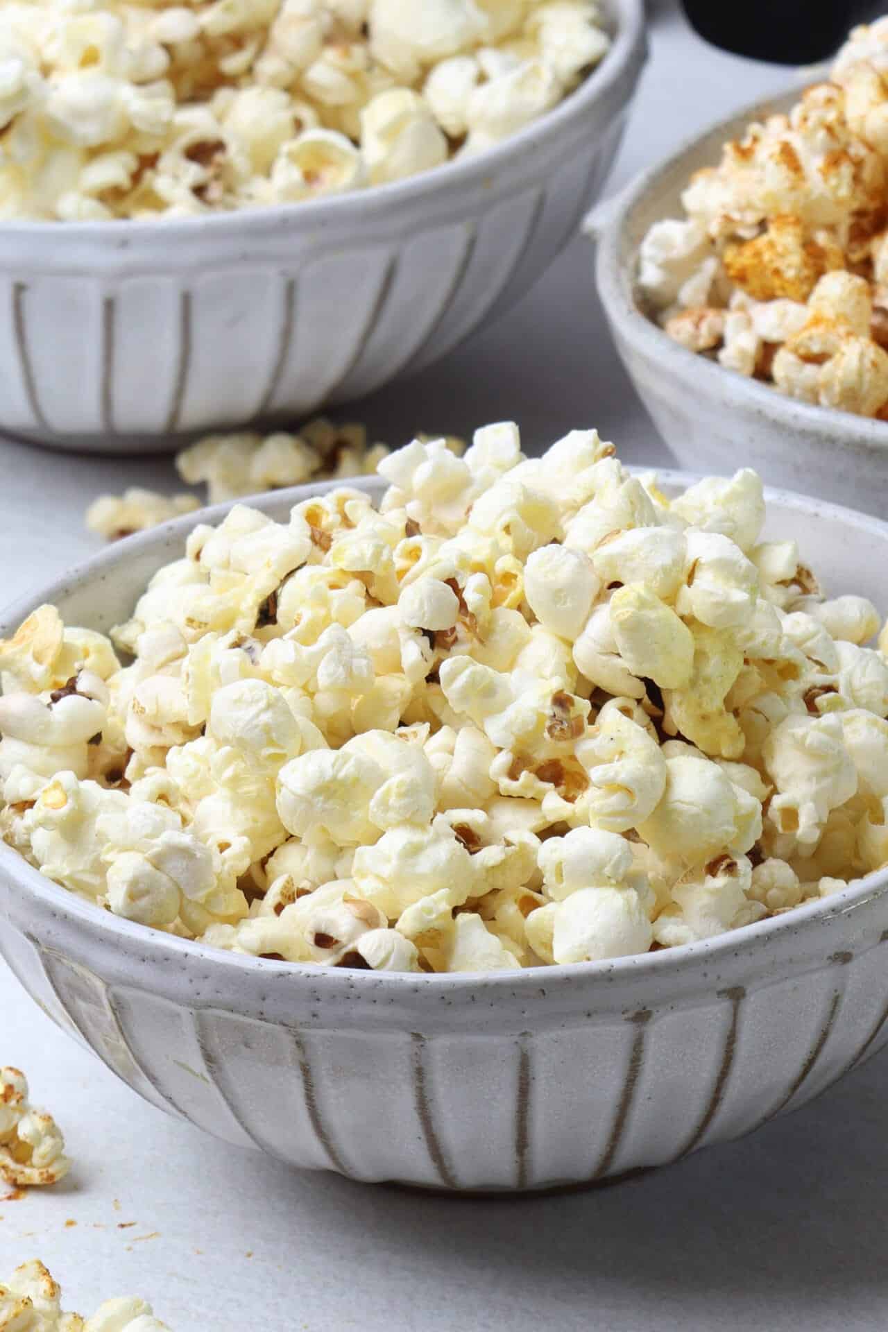 Buttered popcorn in ceramic bowls at Baked Bree.
