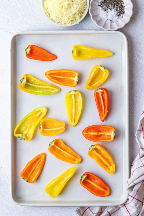Sweet pepper halves on baking sheet, ready for roasting or stuffing. Colorful bell peppers for healthy recipes and dinners.