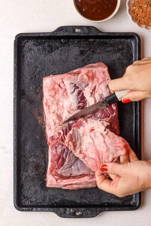 Raw beef brisket on a baking sheet, ready for cooking.