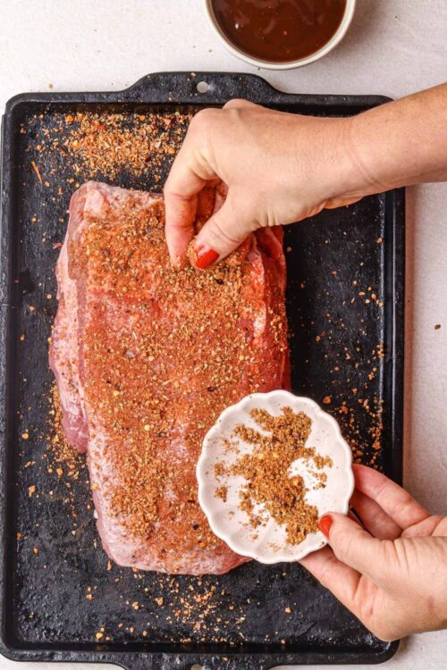 Seasoned beef brisket for roasting on a baking sheet.