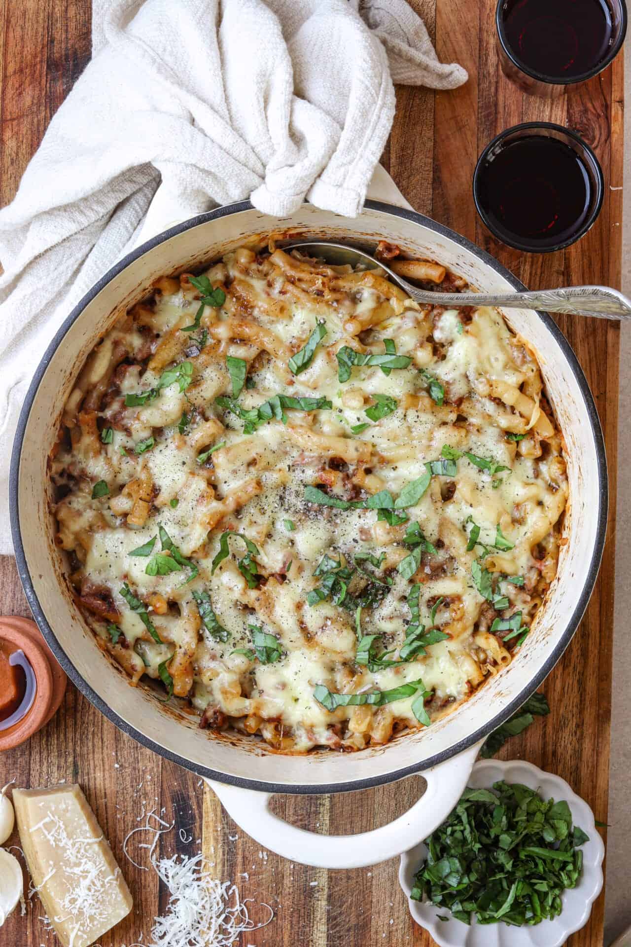 Creamy baked pasta casserole with melted cheese and fresh herbs, served in a rustic dish.