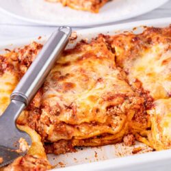 Cheesy lasagna with ground beef and tomato sauce in a baking dish. Delicious Italian comfort food easily made at home.