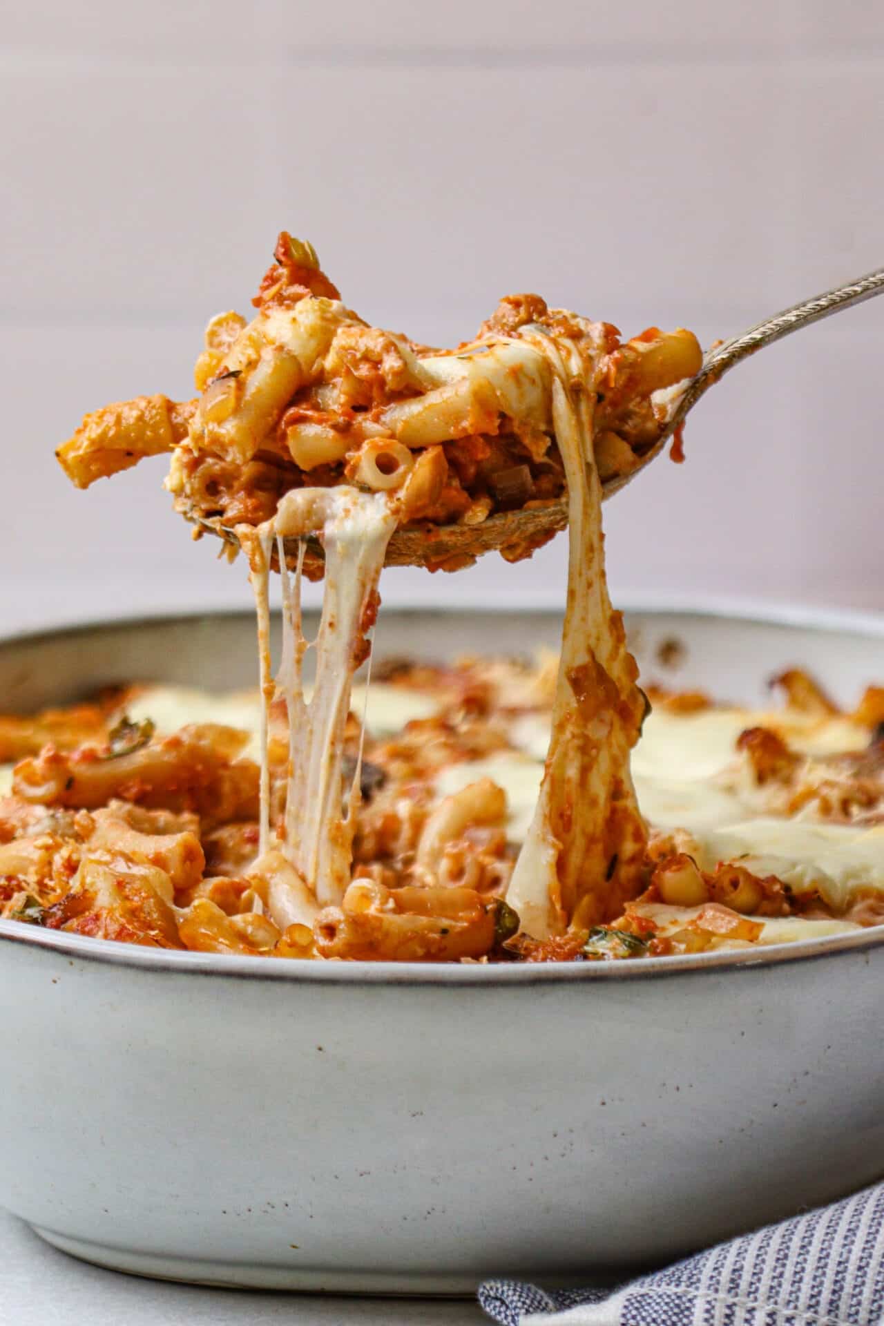 Creamy baked ziti with melted cheese in a white baking dish.