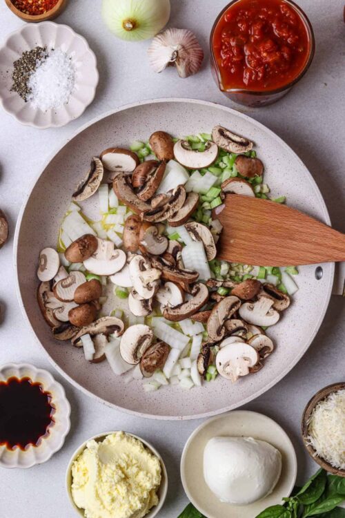 Sautéing mushrooms and onions in a skillet for a flavorful pasta or sauce recipe.