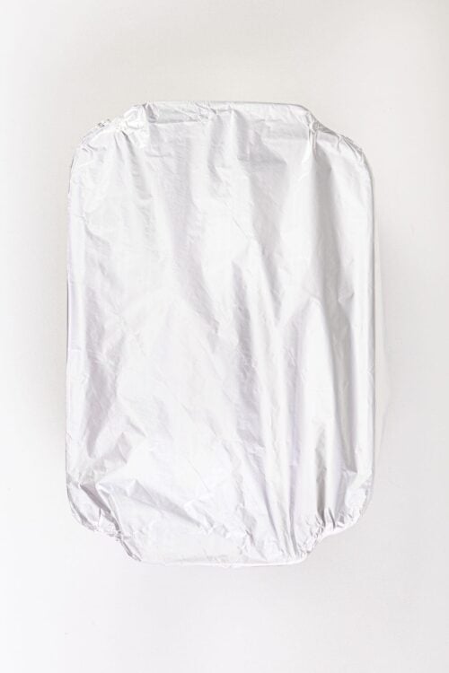 Baked goods covered with aluminum foil, ready for baking or storage.