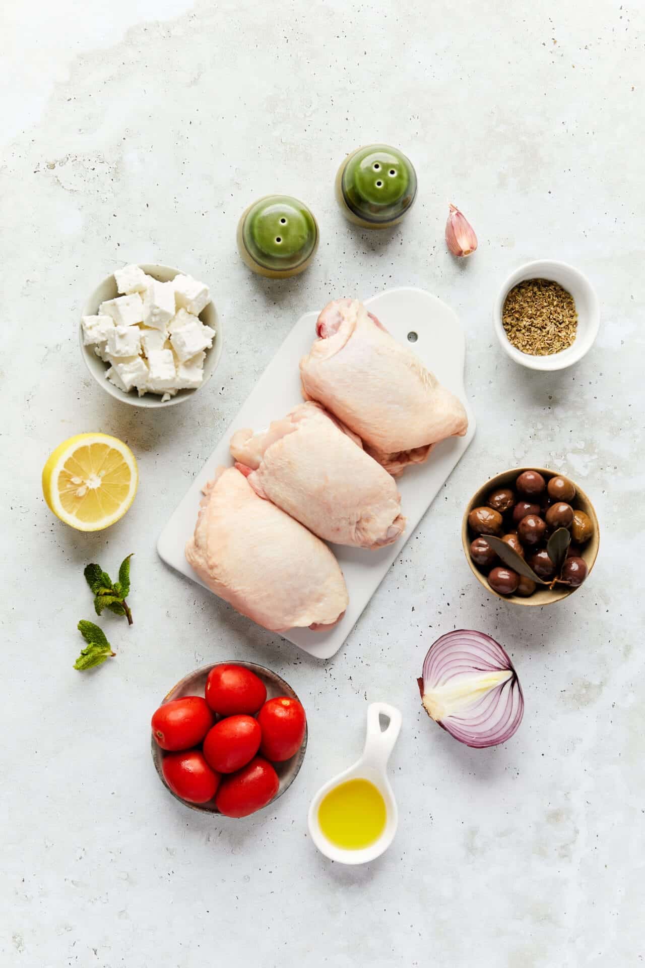 Fresh chicken thighs with vegetables and ingredients for Greek chicken souvlaki recipe.