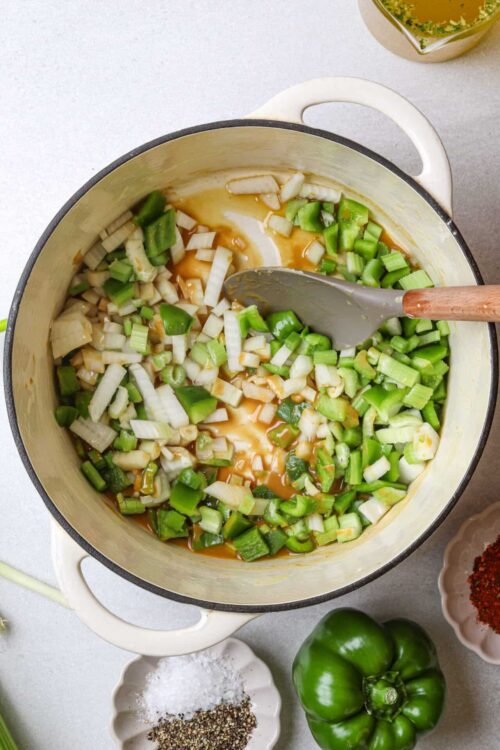 Chopped green onions cooking in a pot with broth and seasonings.