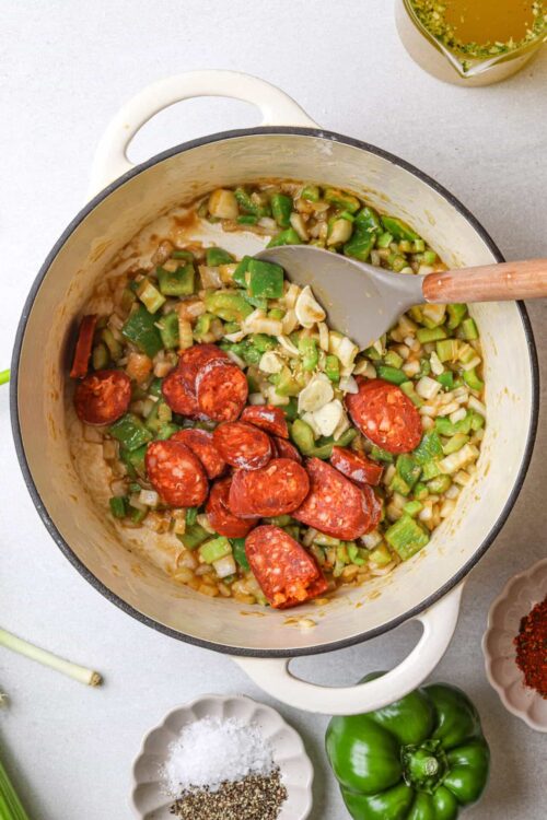 Savory sausage and vegetable skillet with peppers and garlic in a cast iron pan.