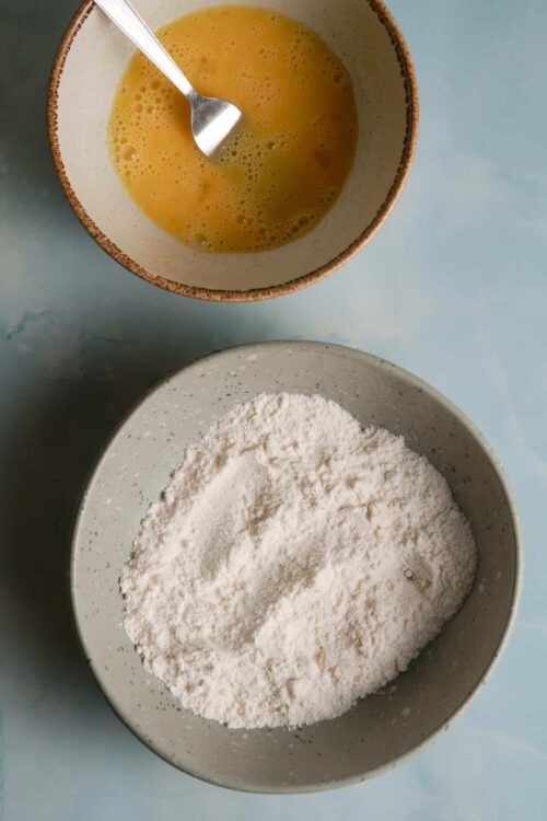 Flour and beaten eggs in bowls for baking bread or cake.