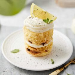 Delicious lemon cake minis topped with whipped cream and lemon wedge for a fresh dessert.